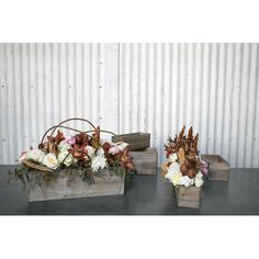 two wooden boxes filled with flowers on top of a table