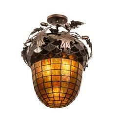 a light hanging from the ceiling with leaves and vines on it's glass shade