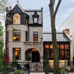 a large brick house with lots of windows and iron railings on the front porch