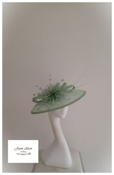 Grace and glamour hatinator in Pistachio green sinamay.  A crisp gentle curved brim is complemented with a low crown, which has been embellished with green pearls.  A sinamay bow plays host to a green starburst feather flower, whilst a pair of ostrich quills add a little drama.  Sits on a headband.  This item has sold, however, similar pieces can be made in a variety of colours.  Please ask for details.  As every piece is handmade, some differences can occur from the photos listed on this site. Spring Fascinator With Sinamay And Curved Brim, Sinamay Fascinator Hat For Spring, Spring Church Fascinator In Sinamay, Spring Sinamay Fascinator Hat, Spring Wedding Cloche Fascinator, Spring Sinamay Fascinator, Spring Church Sinamay Fascinator, Elegant Green Fascinator For Church, Spring Wedding Costume Hats And Headpieces In Sinamay