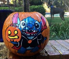 a painted pumpkin sitting on top of a wooden table