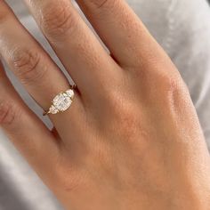 a woman's hand with a diamond ring on it