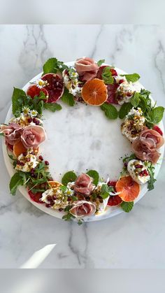 a white plate topped with fruit and veggies on top of a marble counter