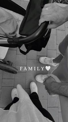 black and white photograph of people sitting on the ground with their feet up in front of them