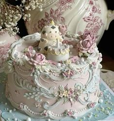 there is a cake decorated with pink flowers and a unicorn on the top, surrounded by other decorations