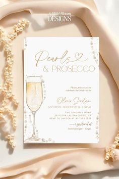 an elegant wedding card with pearls and champagne