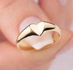 Our signet heart ring is 14k solid gold. Our gold heart ring has a unique style with looks like a folded heart. It fits your all outfit and becomes your everyday ring. When you think of our 14k gold heart ring as a gift, it is a product that will make your loved ones happy on their birthday, valentine's day, mother's day, anniversaries, graduations, or other special days. Also, it can be a perfect gift for yourself. :) 🎁 If you want, you can add a gift note for your loved ones. It arrives in a Polished Heart Ring For Promise, Promise Heart Ring With Polished Finish, 14k Gold Polished Finish Promise Heart Ring, 14k Gold Rings With Heart Charm, Minimalist Polished Heart Ring As Gift, Minimalist Heart Ring With Polished Finish, Heart-shaped Initial Ring In 14k Yellow Gold, Heart Shaped Yellow Gold Signet Ring For Promise, Heart-shaped Yellow Gold Signet Ring For Promise