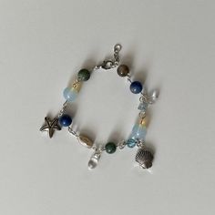 a bracelet with beads and charms on it, including an ocean themed charm bead