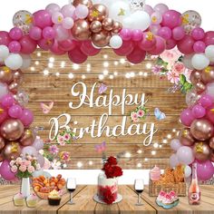 a birthday party with balloons, cake and desserts on a table in front of a wooden backdrop