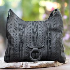 In the Balinese language, anyaman is the word for wicker. Drawing inspiration from wicker designs, Tuniyaton creates this hobo handbag, which is crafted by hand from black leather with intricate patterns that are woven and strung through the leather's surface. A flap conceals a zipper that opens to a faux suede-lined interior with a zipper pocket on one side and an open pocket on the other. Black Woven Leather Rectangular Hobo Bag, Black Leather Woven Hobo Bag, Everyday Rectangular Braided Hobo Bag, Everyday Braided Rectangular Hobo Bag, Leather Hobo Bag With Interwoven Design For Everyday, Black Rectangular Shoulder Bag With Interwoven Design, Leather Tote Bag With Open Weave, Rectangular Hobo Bag With Interwoven Design For Everyday, Everyday Use Rectangular Hobo Bag With Interwoven Design