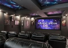 a home theater with black leather seats and stars on the ceiling, along with a projector screen