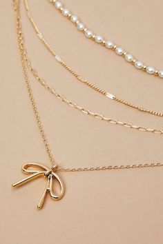 Add a dash of charm to your look with our super dainty and adorable necklace featuring a bow charm and delicate pearl detailing. This elegant accessory exudes timeless beauty, perfect for effortlessly elevating any ensemble with its whimsical and graceful allure. State Necklace, Bow Necklace, Birthday Wishlist, Altard State, Accessories Jewelry Necklace, Elegant Accessories, Altar'd State, Sweater Sale, Gold Pearl