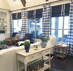 a living room filled with furniture and windows covered in blue checkered drapes