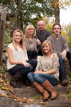 a group of people sitting next to each other on top of a pile of leaves