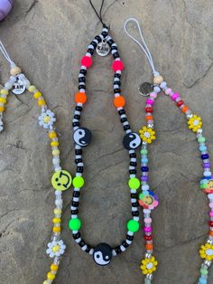 three necklaces with different designs on them sitting on the ground next to each other