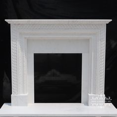 a white marble fireplace surround with intricate carvings on the top and sides, in front of a black background