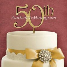 a white cake topped with a gold bow and number fifty - one on top of it