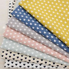 six different colored hearts on white and yellow fabric