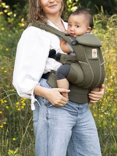 a woman holding a baby in a sling