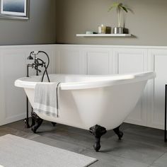 a white bath tub sitting in a bathroom next to a window