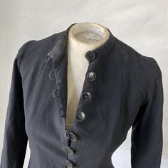 Hello and welcome to the Textile Trunk! Please follow us on Instagram, we are @textiletrunk What a gorgeous piece! This is an amazing wool jacket with a rayon pieced and patched interlining - a super cool effect! This dates right around 1900, and it is a really rare find. I've never seen anything quite like it! The best part of this jacket is the amazing buttons down the front and the loop buttonholes, take a look at the photos. I love this piece, and it would be great for wear or used as design Victorian Long Coat For Fall, Vintage Stand Collar Blazer For Fall, Vintage Stand Collar Blazer For Work, Vintage Fall Blazer With Stand Collar, Vintage Blazer With Stand Collar For Work, Uniform Style Long Coat With Buttons, Vintage Outerwear With Stand Collar And Buttons, Black Button-up Outerwear For Tailoring, Wool Long Sleeve Outerwear For Costumes