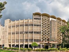 the large building has many windows on it's sides and is surrounded by trees