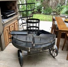 an outdoor bbq with grills and chairs on it's side, in the middle of a patio