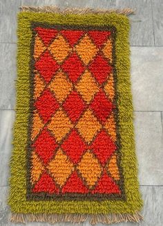 a red and yellow rug on the ground