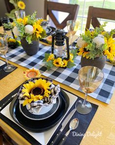 the table is set with sunflowers and place settings