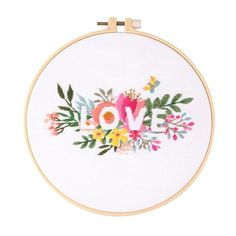 a cross stitch pattern with the word love surrounded by flowers and leaves on a white background