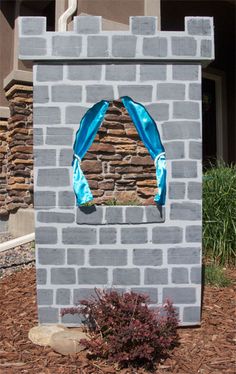 a brick fire hydrant with a blue ribbon around it's arch and window