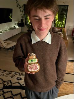 a young man holding a cookie in his hand