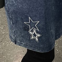 a person wearing a jean jacket with a star design on it's back pocket