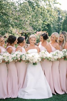 the bride and her bridesmaids are all wearing pink dresses with white bouquets