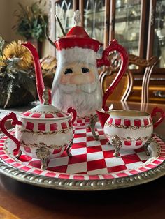 a santa clause figurine sitting on top of a red and white checkered tray