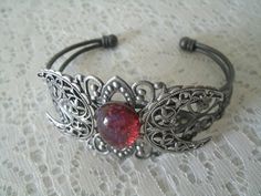 This beautiful silver plated filigree cuff bracelet has a silver plated triple moon design and a glass dragon's breath fire opal setting. Adjustable. Adjustable Mystical Silver Bracelet, Adjustable Silver Mystical Bracelet, Nickel-free Fantasy Jewelry For Festivals, Fantasy Style Silver Bracelet, Silver Fantasy Jewelry For Festivals, Adjustable Silver Fantasy Bracelet, Handmade Silver Gothic Bracelet, Silver Fantasy Bracelet, Silver Gothic Bangle