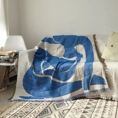 a blue and white blanket sitting on top of a bed