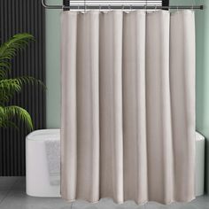 a white shower curtain in a bathroom next to a potted plant