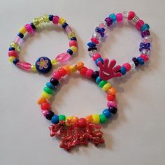 I have been collecting and making kandi since my early rave days in 2000. I will be making special kandi sets that include vintage beads from my collection. Have a little piece of kandi history. I created a playlist on my YouTube channel Kandi Toybox (My kandi bead collection) if you would like to see my collection! These kandi bracelets are made with mostly vintage beads from the 90s,early 2000s and some new beads. New beads are the glitter pony beads. Includes 3 bracelets. Bracelet size 7-8 in Rainbow Beaded Bracelets For Rave And Friendship, Rainbow Beaded Bracelets For Friendship Rave, Rainbow Beaded Bracelets For Friendship, Rave Style Colorful Beaded Bracelets For Festival, Rave Style Festival Beaded Bracelets With Colorful Beads, Rave Style Plastic Beaded Bracelets, Colorful Rave Beaded Bracelet, Multicolor Rave Jewelry For Party, Fun Rainbow Bracelets For Party