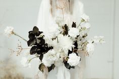 a bride holding a bouquet of white flowers