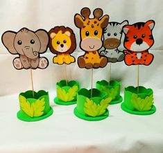 there are some cupcake toppers that have animals on them and leaves in the middle