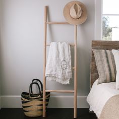 a hat, towel rack and basket in a bedroom