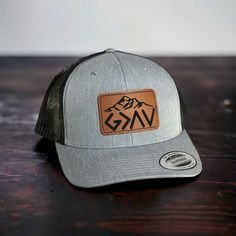 This is a custom made leather patch Hat!   These are made to order. Hat brand is Yupoong 6606 ! Trucker  style Hat with a SnapBack design.  Custom God is Greater Than the Highs and Lows Patch design !  Please choose your color of hat you would like and color of patch.  Leather Patches are bonded to all hats **not stitched on** We use a powerful leather bonding and heat pressed for maximum bonding to the hat .  We Do Custom Orders !  If you want a specific brand of hat or color feel free to messa Gray Outdoor Hat With Logo Patch, Christian Hats For Men, Custom Outdoor Hat With Flat Bill, Custom Flat Bill Hat For Outdoor, Custom Flat Brim Hats With Leather Patch, Trucker Hat With Leather Patch And Short Brim, Outdoor Short Brim Hats With Logo Patch, Outdoor Trucker Hat With Leather Patch And Short Brim, Custom Outdoor Snapback Hat