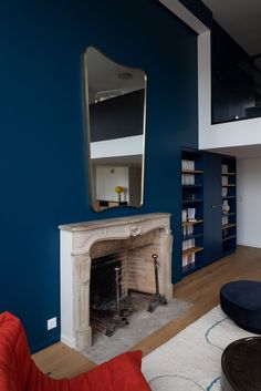 a living room filled with furniture and a fire place in front of a blue wall