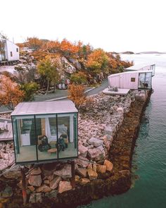 an aerial view of a house on the water's edge with people in it