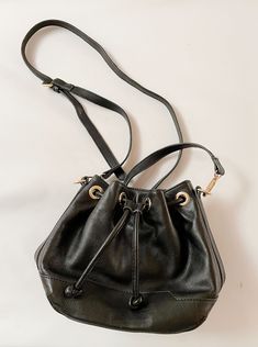 "A cute Rebecca Minkoff bucket bag has a drawstring top with a magnetic closure. Cotton floral interior has a few little pockets. Has gold-tone hardware. Size approx: 8 tall by 9.5 wide at bottom, 4.6\" depth at bottom Strap: set to 46\" but can be made longer. Condition: GOOD. Very light wear. Clean. Thanks for looking!  International buyers, please contact me regarding shipping costs. And please do visit my store home page: https://www.etsy.com/shop/LionandLambVintage" Everyday Bucket Shoulder Bag With Gold-tone Hardware, Chic Bucket-shaped Hobo Bag For On-the-go, Gold-tone Hardware Bucket Shoulder Bag, Chic Bucket Bag For On-the-go, Gold Bucket Bag With Adjustable Strap, Gold Bucket Bag With Dust Bag For Daily Use, Daily Use Bucket Shoulder Bag With Gold-tone Hardware, Gold-tone Hardware Bucket Shoulder Bag For Daily Use, Everyday Bucket Satchel With Gold-tone Hardware