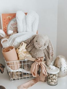 a basket filled with lots of items on top of a white table next to a stuffed animal