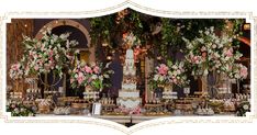 a table topped with lots of cakes and desserts covered in flowers on top of it