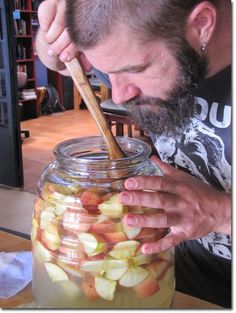 a man with a spoon in a jar filled with apples