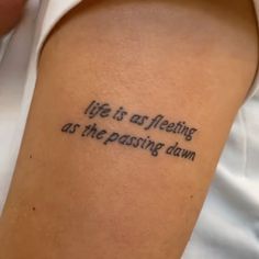 a person with a tattoo on their arm that says life is aftering as the passing dawn